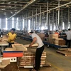 Sản xuất đồ gỗ tại Công ty TNHH MTV Triệu Phú Lộc, thị xã Tân Uyên. (Ảnh: Chí Tưởng/TTXVN)