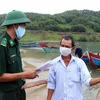Cán bộ, chiến sỹ Đồn Biên phòng Lăng Cô tuyên truyền phòng chống dịch bệnh COVID-19 cho ngư dân ở thị trấn Lăng Cô, huyện Phú Lộc. (Ảnh: Đỗ Trưởng/- TTXVN)