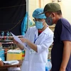 Nhân viên y tế hướng dẫn lái xe khai báo y tế tại chốt kiểm soát dịch bệnh Thừa Thiên-Huế. (Ảnh: Đỗ Trưởng/TTXVN)