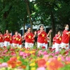 Người dân Thủ đô mặc đồng phục cờ Tổ quốc biểu diễn bài tập dưỡng sinh bên hồ Gươm sáng 2/9. (Ảnh: TTXVN)