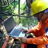 Cán bộ Điện lực thị xã Cừa Lò trích xuất dữ liệu lưu trữ tại các côngtơ điện tử của các hộ dân để xác minh vụ việc. (Ảnh: Tá Chuyên/TTXVN)