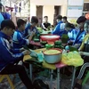 Các em Trường THPT Nguyễn Cảnh Chân, huyện Thanh Chương (Nghệ An) gói bánh chưng ủng hộ đồng bào lũ lụt các tỉnh miền Trung. (Ảnh: TTXVN phát)