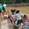 Các nhà tài trợ vận chuyển quà qua suối để cứu trợ cho người dân xã miền núi Vĩnh Ô, huyện Vĩnh Linh, Quảng Trị do giao thông bị chia cắt. (Ảnh: Hồ Cầu/TTXVN)