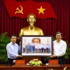 Tổng Giám đốc TTXVN Nguyễn Đức Lợi tặng bức ảnh lãnh đạo thành phố Cần Thơ tại buổi làm việc với Bộ Chính trị do phóng viên TTXVN chụp. (Ảnh: Ngọc Thiện/TTXVN)