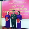 Thượng tá Ngô Nam Cường, Chỉ huy trưởng Bộ Chỉ huy Quân sự tỉnh Thừa Thiên-Huế trao quyết định tuyển dụng và trao quân hàm cho thân nhân liệt sỹ. (Ảnh: TTXVN phát)