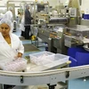 Nhân viên công ty CSL thu nhặt thành phẩm trên dây chuyền sản xuất vắcxin tại Melbourne, Australia. (Ảnh: AFP/TTXVN)