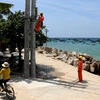 EVN lắp đặt côngtơ cho khách hàng dùng điện trên đảo Nhơn Châu (Bình Định). (Ảnh: Ngọc Hà/TTXVN)
