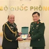 Thượng tướng Hoàng Xuân Chiến trao biểu tượng Bộ Quốc phòng Việt Nam tặng Đại tá Rem Kan, Tùy viên Quân sự Campuchia tại Việt Nam. (Ảnh: Hồng Pha/TTXVN phát)