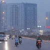Người dân Hà Nội phải di chuyển trong tình trạng ô nhiễm không khí. (Ảnh: Hoàng Hiếu/TTXVN)