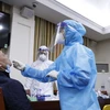 Nhân viên y tế lẫy mẫu xét nghiệm virus SARS-CoV-2 cho các phóng viên, biên tập, kỹ thuật viên các cơ quan thông tấn, báo chí. (Ảnh: Dương Giang/TTXVN)