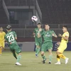 Pha tranh bóng giữa các cầu thủ đội chủ nhà Sài Gòn FC (áo xanh) và SLNA (áo vàng). (Ảnh: Thanh Vũ/TTXVN)