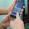 Hướng dẫn người dân cài đặt ứng dụng Bluezone trên thiết bị điện thoại thông minh để phòng chống dịch bệnh COVID-19. (Ảnh: Chương Đài/TTXVN)