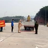 Lực lượng chức năng gỡ bỏ trang thiết bị tại chốt kiểm dịch Trạm thu phí cao tốc Vân Đồn-Hạ Long. (Ảnh: TTXVN phát)