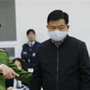 Cảnh sát dẫn giải bị cáo Đinh La Thăng, cựu Chủ tịch Hội đồng quản trị Tập đoàn Dầu khí Việt Nam (PVN) trong phiên xét xử sáng 22/1. (Ảnh: Doãn Tấn/TTXVN)
