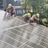 Đoàn viên thanh niên Tổng Công ty Điện lực Thành phố Hồ Chí Minh lắp đặt hệ thống điện năng lượng mặt trời tại Làng Thiếu niên Thủ Đức. (Ảnh: Hồng Giang/TTXVN)