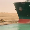 Chiếc máy xúc đứng cạnh siêu tàu chở hàng Ever Given mắc cạn tại Kênh đào Suez, Ai Cập, ngày 24/3. (Ảnh: THX/ TTXVN)