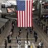 Hành khách chờ làm thủ tục tại sân bay John F. Kennedy ở New York, Mỹ ngày 13/5/2020. (Ảnh: AFP/TTXVN)