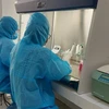 Nhân viên y tế chạy thử nghiệm máy xét nghiệm COVID-19 tại cơ sở xét nghiệm mới - Trung tâm kiểm soát bệnh tật tỉnh Long An. (Ảnh: Đức Hạnh/TTXVN)