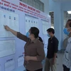 Cử tri huyện Vĩnh Thuận, Kiên Giang xem tiểu sử những người ứng cử đại biểu Quốc hội và HĐND các cấp. (Ảnh: Lê Sen/TTXVN)