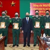 Chủ tịch nước Nguyễn Xuân Phúc tặng ảnh chân dung Chủ tịch Hồ Chí Minh cho cán bộ Bộ Tư lệnh Quân khu 7. (Ảnh: Thống Nhất/TTXVN)