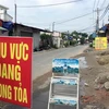 Lực lượng chức năng phong tỏa một đoạn đường TL19 (Khu phố 3B, phường Thạnh Lộc, Quận 12, Thành phố Hồ Chí Minh). (Ảnh: Tiến Lực/TTXVN)