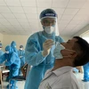 Nhân viên y tế lấy mẫu xét nghiệm COVID-19 cho người dân tại khu phố 1, phường 15, quận Gò Vấp, ngày 29/5. (Ảnh: TTXVN phát)