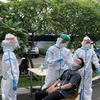 Các y, bác sỹ Trung tâm kiểm soát bệnh tật Tp Hồ Chí Minh và Quận 7 thực hiện xét nghiệm sàng lọc COVID-19 ngẫu nhiên cho công nhân ở Khu chế xuất Tân Thuận. (Ảnh: Thanh Vũ/TTXVN)
