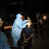 Lực lượng y bác sỹ xuyên đêm lấy mẫu xét nghiệm đối với các trường hợp là F1 của bệnh nhân số 11634 ở huyện Diễn Châu, Nghệ An. (Ảnh: Văn Tý/TTXVN)
