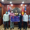 Đại diện Chính quyền tỉnh Bokeo trao tặng tiền hỗ trợ 3 tỉnh của Việt Nam phòng, chống dịch COVID-19. (Ảnh: TTXVN phát)