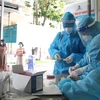 Sinh viên y khoa chuẩn bị lấy mẫu xét nghiệm cho người dân tại khu vực phường 3, Quận 3. (Ảnh: Hồng Giang/TTXVN)