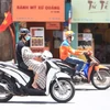 Người dân che, chắn trong đợt nắng nóng cục bộ tại Hà Nội. (Ảnh: Hoàng Hiếu/TTXVN)