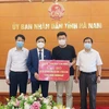 Tiếp nhận ủng hộ 100 triệu đồng từ Công ty TNHH may Kim Bình. (Ảnh: Nguyễn Chinh/TTXVN)