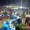 Các y, bác sỹ của Trung tâm y tế huyện Thống Nhất đang làm test nhanh COVID-19 cho 320 người tại Chợ đầu mối Dầu Giây vào đêm 10/7. (Nguồn: baodongnai.vn)