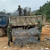 Cán bộ, chiến sỹ Bộ chỉ huy Quân sự tỉnh Thừa Thiên-Huế chuẩn bị rọ đá để sẵn sàng nắn dòng suối Rào Trăng tìm kiếm nạn nhân. (Ảnh: TTXVN phát)