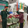 Đại diện Sư đoàn 302 trao sản phẩm từ “Siêu thị 0 đồng di động” cho người dân xã Châu Pha. (Ảnh: Huỳnh Ngọc Sơn/TTXVN)