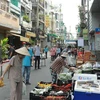 Người dân mua hàng hóa thiết yếu tại một Phiên chợ lưu động được tổ chức tại khu phố 3, phường 2, Quận 3, Thành phố Hồ Chí Minh. (Ảnh: Quang Châu/TTXVN)