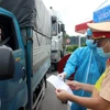Lực lượng chức năng tỉnh Phú Thọ kiểm tra giấy xét nghiệm âm tính với COVID-19 của lái xe tải ở địa phương khác vào tỉnh Phú Thọ. (Ảnh: Trung Kiên/TTXVN)