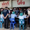 Người dân xếp hàng chờ xét nghiệm COVID-19 tại Samut Sakhon, Thái Lan. (Ảnh: AFP/TTXVN)