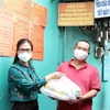 Đại diện Ủy ban MTTQ Việt Nam TP trao quà cho lao động nghèo, gặp khó khăn do ảnh hưởng dịch bệnh COVID-19 tại phường Hiệp Thành, Quận 12. (Ảnh: Xuân Khu/TTXVN)