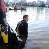 Lực lượng tìm kiếm cứu nạn tìm kiếm hai cháu trên hồ Tiên Nga. (Ảnh: Hoàng Ngọc/TTXVN)