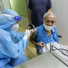 Các y bác sỹ bệnh viện Phú Nhuận thực hiện tiêm vaccine cho người trên 65 tuổi, người có bệnh nền tại Trung tâm y tế phường 11, quận Phú Nhuận. (Ảnh: Thanh Vũ/TTXVN)