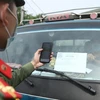 Lực lượng chức năng tại chốt kiểm soát đầu cầu Trung Hà (huyện Ba Vì) quét mã QR Code kiểm tra thông tin phương tiện theo đăng ký khi qua chốt. (Ảnh: Minh Quyết/TTXVN)