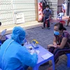 Thu thập thông tin người dân trước khi lấy mẫu xét nghiệm SARS-CoV-2 trong ngày đầu thực hiện “ai ở đâu thì ở đó.” (Ảnh: Trần Lê Lâm/TTXVN)