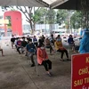 Người dân ngồi xếp hàng để được tiêm vaccine Vero Cell tại điểm tiêm Trung tâm văn hóa phường Phú Lợi, thành phố Thủ Dầu Một, tỉnh Bình Dương. (Ảnh: Chí Tưởng/TTXVN)