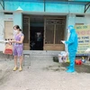 Nhân viên y tế trạm y tế lưu động phường 25, quận Bình Thạnh phát túi thuốc cho F0 điều trị tại nhà. (Ảnh: Đinh Hằng/TTXVN)
