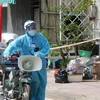Lực lượng chức năng thị trấn Phú Mỹ, huyện Phú Tân tăng cường công tác tuyên truyền lưu động đến tận sâu trong các khu phong tỏa nhằm nhắc nhỏ, nâng cao ý thức phòng, chống dịch của người. (Ảnh: Công Mạo/TTXVN)