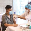 Nhân viên y tế tiêm vaccine phòng COVID-19 cho người dân quận Hoàn Kiếm, chiều 15/9. (Ảnh: Minh Quyết/TTXVN)