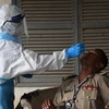Nhân viên y tế lấy mẫu xét nghiệm COVID-19 cho người dân tại Phnom Penh, Campuchia ngày 16/8. (Ảnh: AFP/TTXVN)