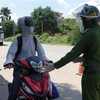 Người từ các tỉnh phía Nam đi xe mô tô về quê được Công an thành phố Đà Nẵng hướng dẫn, đảm bảo an toàn khi đi qua địa bàn thành phố. (Ảnh: Quốc Dũng/TTXVN)