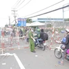 Lực lượng công an phân luồng, đảm bảo an ninh trật tự tại khu vực người dân tập trung trên Quốc lộ 1, đoạn qua Thị trấn Tân Túc, huyện Bình Chánh, Thành phố Hồ Chí Minh. (Ảnh: TTXVN phát)